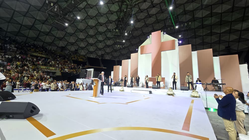 Escenario y líderes ante el auditorio en el encuentro de fe
