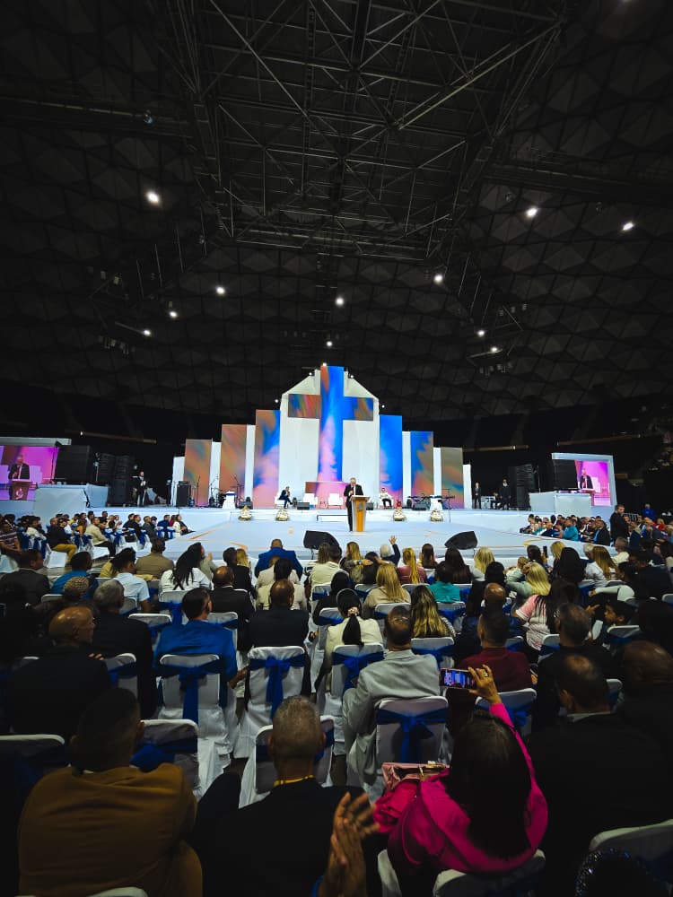 Congregación frente al escenario con la cruz en el encuentro de fe